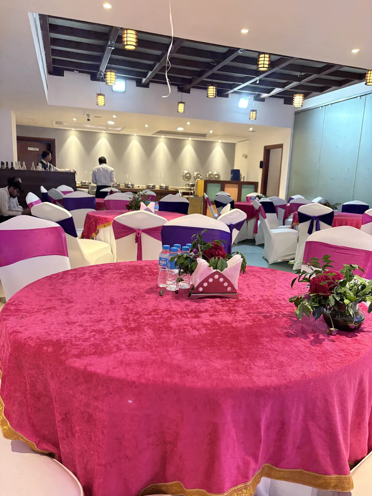 JK Hotel in-house restaurant dining area with dark wooden tables and high-back chairs