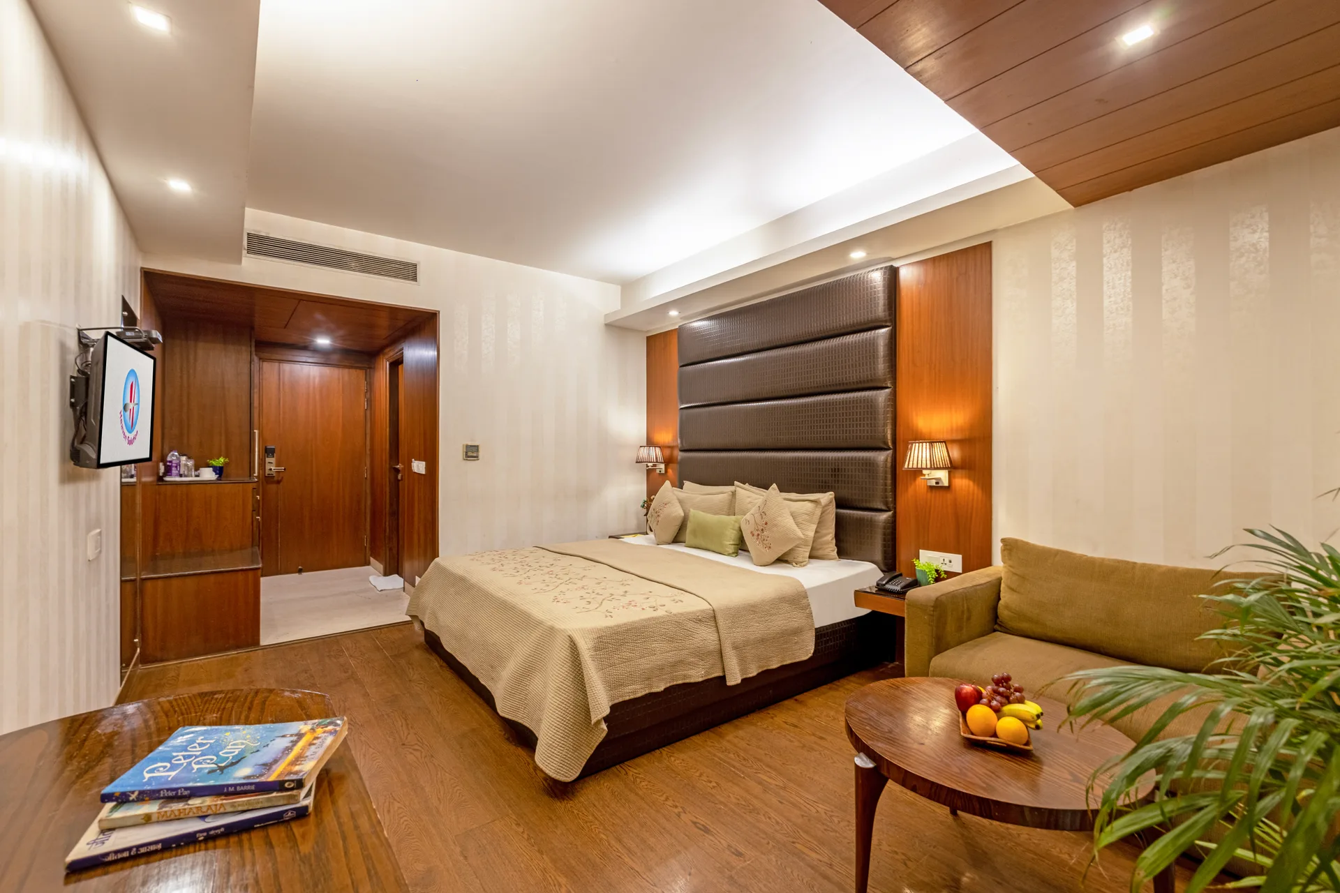 JK Hotel deluxe room with king bed, sofa and modern decor — comfortable stay in C R Park, South Delhi
