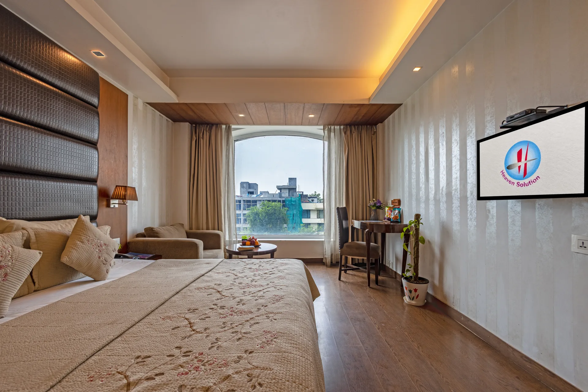 JK Hotel junior suite bedroom with large bay window and premium city views — hotel in Chittaranjan Park Delhi